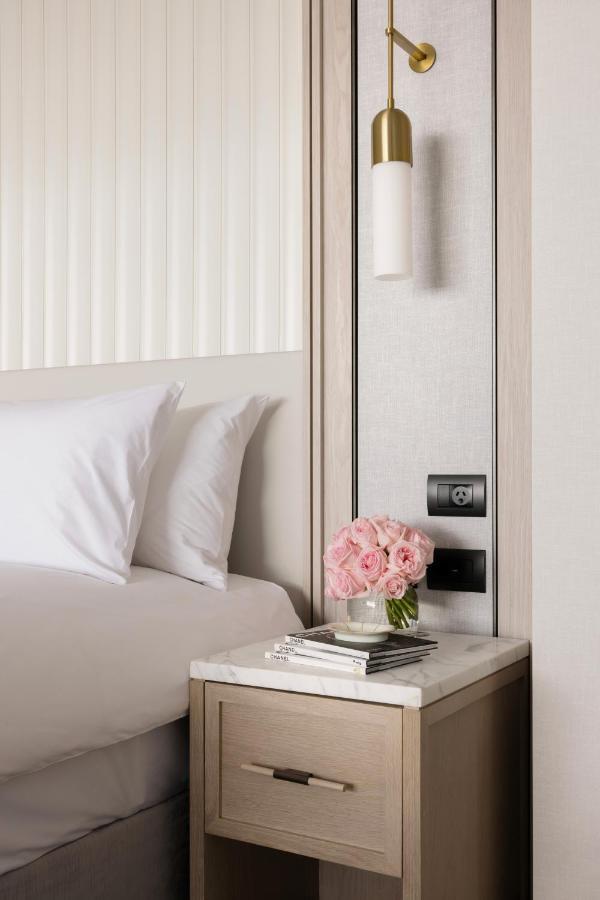 The Langham, Gold Coast And Jewel Residences Екстер'єр фото A bedside table with a lamp, a telephone and a vase of flowers